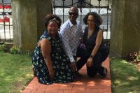Three people posed next to Westports brick exhibit